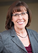 Professional portrait of a smiling woman in business dress.