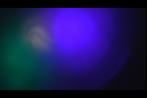 Image of Blurred out blue and green lights against a black background.