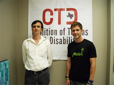 Two men stand in front of a CTD banner, one with a reserved expression, the other smiling at the camera.